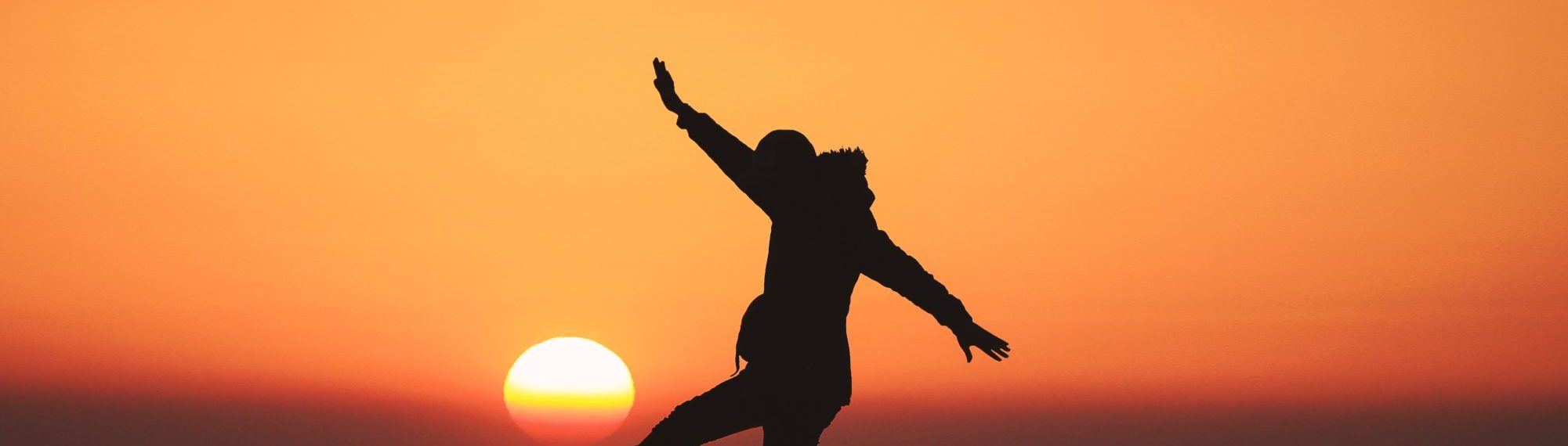 Silhouette of person in front of setting sun