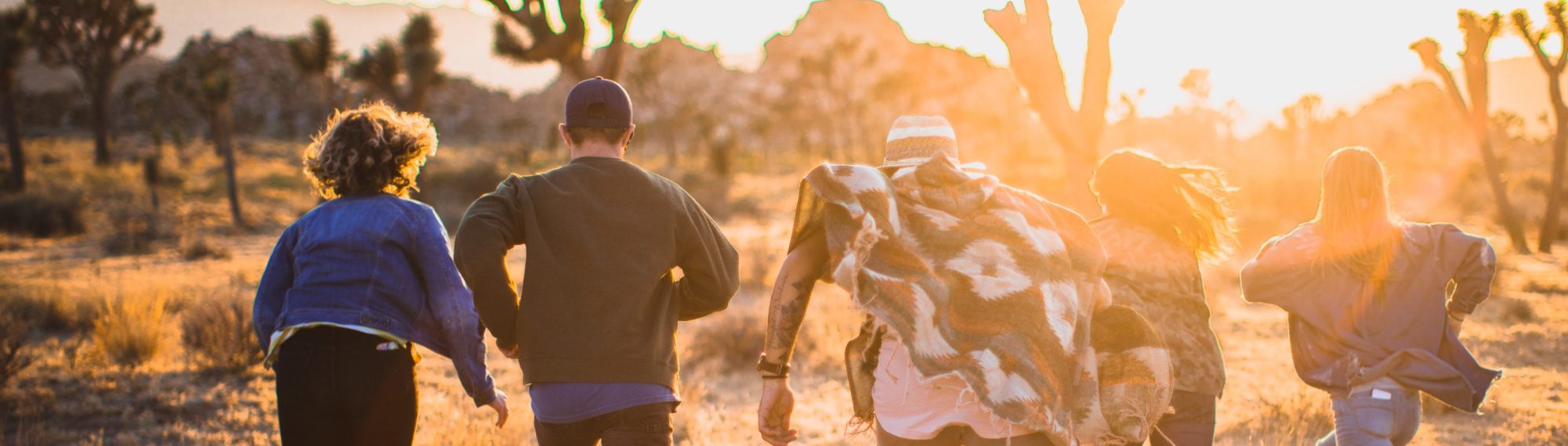 Young people running toward the sunset